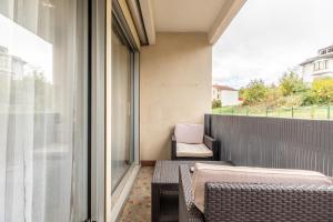 ein Balkon mit einer Couch und einem Laptop darauf in der Unterkunft F3 charmant neuf et équipé avec balcon "Wailly" in Clermont-Ferrand