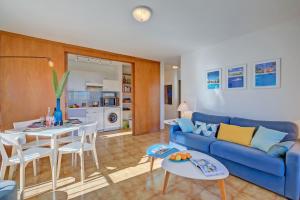 uma sala de estar com um sofá azul e uma mesa em Cap et Soleil - Happy Rentals em Antibes