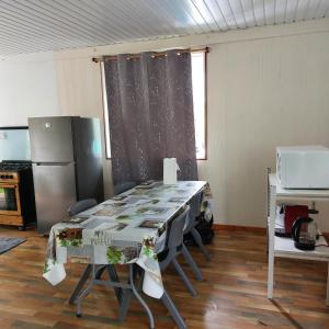 Habitación con mesa con sillas y nevera. en Maruhana lodge, en Teahupoo
