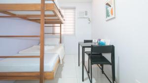 a bedroom with a bunk bed and a desk with a chair at Catlea Inn in Manila