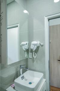 a bathroom with a white sink and a mirror at The Mansion Hotel Bien Hoa in Bien Hoa