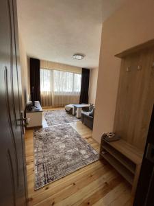 una sala de estar con un sofá y una alfombra en The Chestnut Apartments - Апартаменти Кестените, en Velingrad