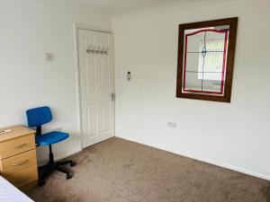 1 dormitorio con escritorio, silla y espejo en Large guest Room en Maidenhead