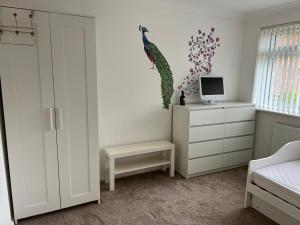 a bedroom with a bed and a desk with a computer at Large guest Room in Maidenhead