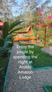 une image d'une maison dans un jardin dans l'établissement Aroldo Amazon Lodge, à Puerto Maldonado