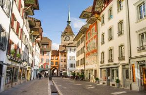 eine leere Straße in einer Stadt mit einem Uhrturm in der Unterkunft Aarauerhof - Self Check-in in Aarau