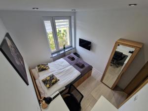 een kleine slaapkamer met een bed en een spiegel bij YourSecondFlat Sobieski Apartment in Dębica