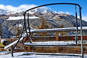 a swing in the snow with mountains in the background at Hotel Chacaril in Pila