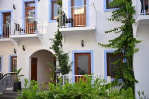 een appartementencomplex met witte muren en blauwe balkons bij Manuela Boutique Hotel Bitez in Bitez