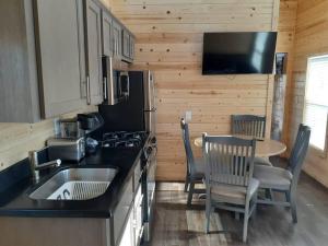 a kitchen with a sink and a table with chairs at 092 Star Gazing Tiny Home near Grand Canyon South Rim Sleeps 8 in Valle