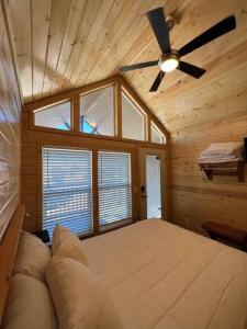 a bedroom with a large bed with a ceiling fan at 092 Star Gazing Tiny Home near Grand Canyon South Rim Sleeps 8 in Valle