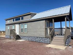 a small house with a porch and a deck at 092 Star Gazing Tiny Home near Grand Canyon South Rim Sleeps 8 in Valle