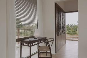 escritorio y silla en una habitación con ventana en Nhãn Stay en Thôn Dương Xuân Hạ