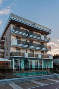 an apartment building with a pool in front of it at Hotel Ascot Riccione in Riccione