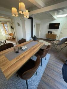 sala de estar con mesa de madera y sillas en Ferienhaus Sprotte, en Bredstedt
