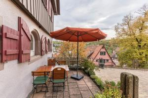 a table and chairs with an umbrella on a patio at Ferienwohnungen Metzgerpost in Altensteig