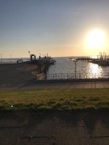 een pier met zonsondergang boven het water bij Ferienhaus Sprotte in Bredstedt