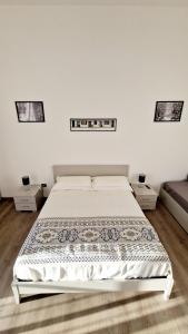 a white bedroom with a bed and two night stands at Puteoli Sea View in Pozzuoli