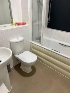 uma casa de banho com um WC, um chuveiro e um lavatório. em Central Town Apartment em Kent