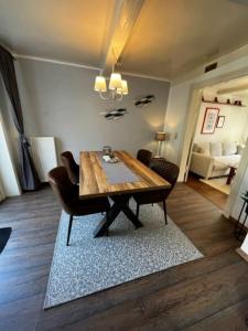een eetkamer met een houten tafel en stoelen bij Ferienhaus Sprotte in Bredstedt