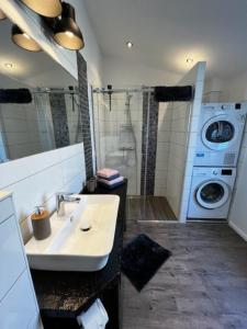 een badkamer met een wastafel en een wasmachine bij Ferienhaus Sprotte in Bredstedt
