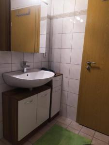 baño con lavabo, espejo y puerta en Haus Mila, en Freudenstadt