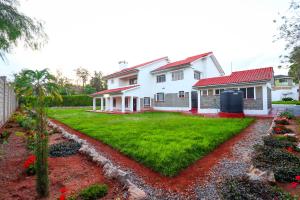 a white house with a yard with red roof at Enashipai Holiday Homes in Makandara