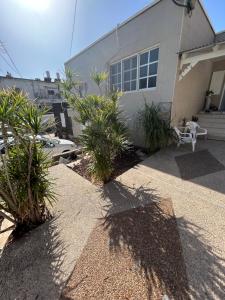 uma casa com uma cadeira branca e plantas em frente em Casa de Galilee em Tiberias