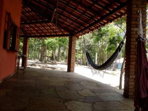- une terrasse couverte avec un hamac suspendu à un bâtiment dans l'établissement Camping Guapira, à Vale do Capão