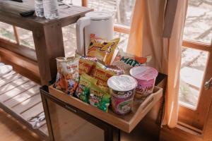 a shelf with a bunch of snacks and a refrigerator at Mơ Garden Retreat DaLat in Da Lat