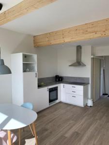 una cucina con armadi bianchi, tavolo e tavolo e un tavolo nuovo di Camping du Château a Granges-sur-Vologne