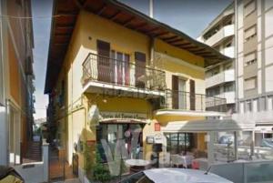 切塞納蒂科的住宿－CASA FIORENTINI CESENATICO，黄色的建筑,设有阳台和桌子