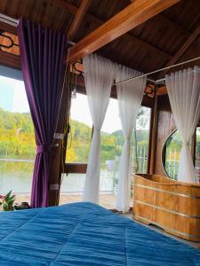 a bedroom with a bed with purple and white curtains at Nha Ben Ho Venuestay in Hanoi