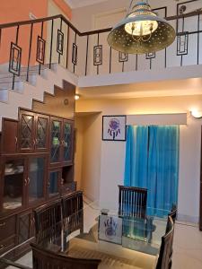 jadalnia ze szklanym stołem i schodami w obiekcie Vijaya's Homestead Jaipur w mieście Dżajpur