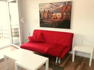 um sofá vermelho numa sala de estar com um quadro em Wohnung 2 Ensingerstrtaße em Ulm