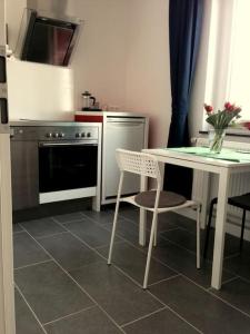 uma cozinha com uma mesa e uma mesa e cadeiras brancas em Wohnung 2 Ensingerstrtaße em Ulm
