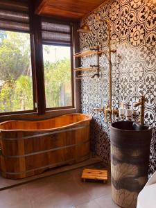 a large wooden tub in a bathroom with a window at Nha Ben Ho Venuestay in Hanoi