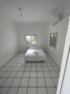 a white room with a bed and a tiled floor at Casa de Galilee in Tiberias