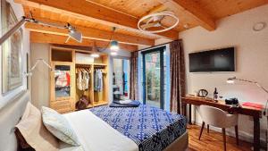 Schlafzimmer mit einem Bett, einem Schreibtisch und einem TV in der Unterkunft d'ARTEmisia Chambres d'hôtes in Pont-Saint-Martin