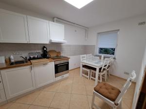 a kitchen with white cabinets and a table and chairs at Biggesee-Sauerland in Drolshagen