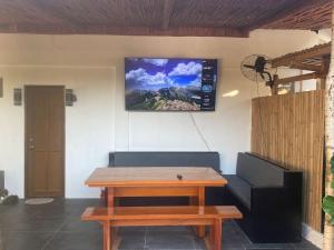 a living room with a couch and a tv on the wall at Angelito's Beach House 4 bedroom in General Luna