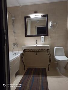 a bathroom with a sink and a toilet and a mirror at ЭкоДом in Bilhorod-Dnistrovsʼkyy