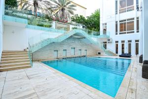 a swimming pool with a staircase next to a building at Luxury 7BR Villa with Premium Amenities - Private Cinema, Pool and Gym -Emirates Hills in Dubai