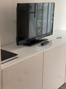 a flat screen tv sitting on top of a dresser at Ruhige Ferienwohnung in Heskem - Berthold Apartments in Heskem