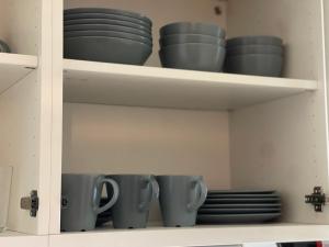 a cupboard filled with plates and mugs and bowls at Ruhige Ferienwohnung in Heskem - Berthold Apartments 