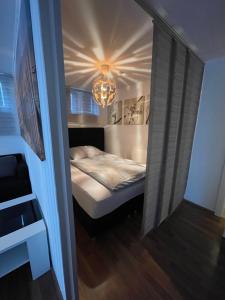a small bedroom with a bed and a chandelier at Ruhige Ferienwohnung in Heskem - Berthold Apartments 