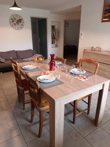 uma mesa de madeira com cadeiras e uma sala de jantar em Chemin du Grand Pré em Gripport