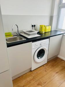 a kitchen with a sink and a washing machine at Large guest Room in Maidenhead