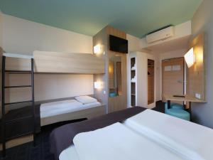 1 Schlafzimmer mit 2 Etagenbetten und einem Schreibtisch in der Unterkunft B&B Hotel Potsdam in Potsdam