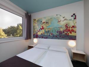 - une chambre avec un lit orné d'une peinture murale dans l'établissement B&B Hotel Potsdam, à Potsdam